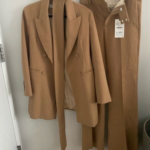 Camel colored suit blazer with belt and flare pant.